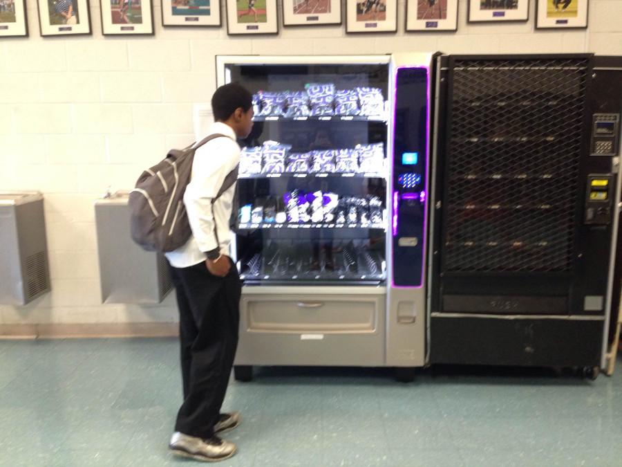 A student buys gear from the Chantilly spirit vending machine located in the gym lobby.