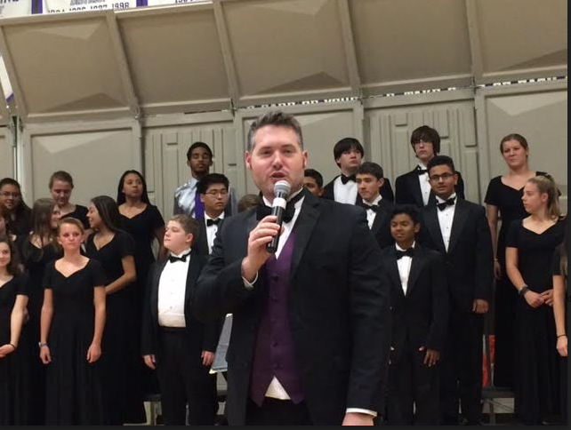 Choral director Evan Ayers leads in the performance.
