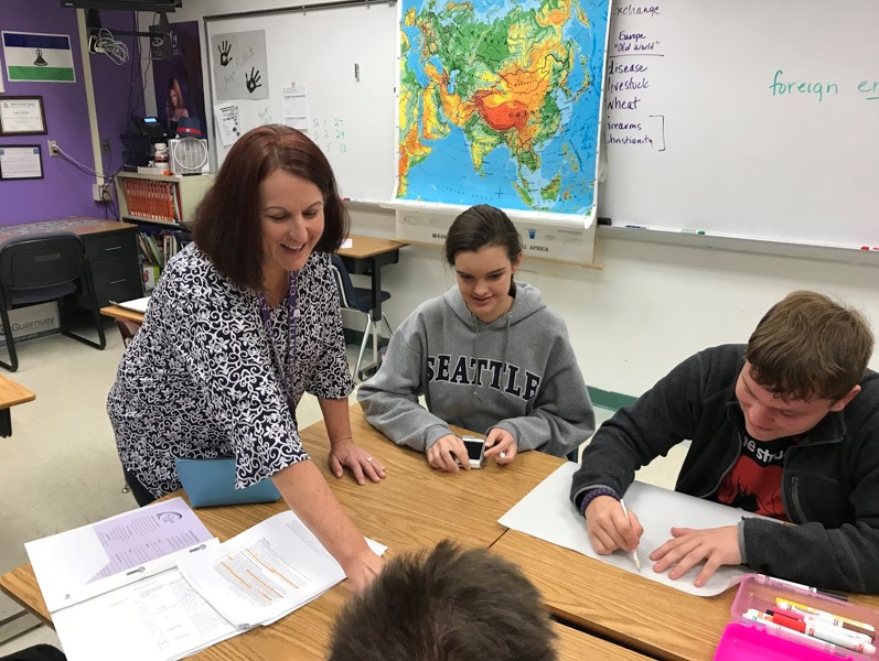 Social studies teacher Angie Rollet assists sophomores Anthony Exley and Rachel Walls on a history project. Rollet is known for her attempts to create a positive working environment.  