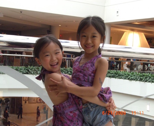 Senior and fraternal twins Annie and Yannie Wu embrace in a hug as they spend the day together at Tysons Corner. When they were younger, they often wore matching clothes and engaged in the same activities.