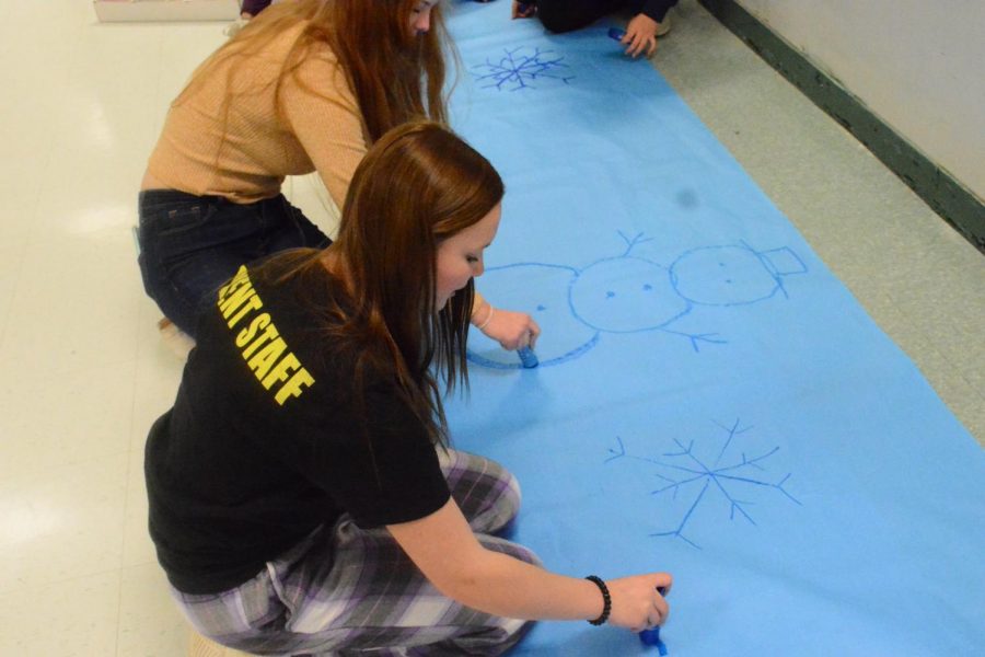 Sophomore Katie Webster and Natalie Hogan prepare for Sno-Co by creating winter-themed posters and banners. Leadership students have been working on making decorations for the past week. 