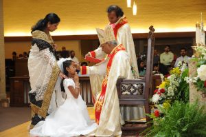 This photo depicts Nayana Celine Xavier getting confirmed on her First Holy Communion and Confirmation day. Communion and Confirmation mark an individuals acceptance of Christianity, a religion that offers a sense of strength and guidance in Celine Xaviers life.  