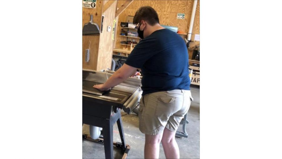 Senior Alexander Alvarez volunteers at Michaels Woodshop at Camp Snyder in Haymarket). He is helping scouts build projects to get some extra experience. 