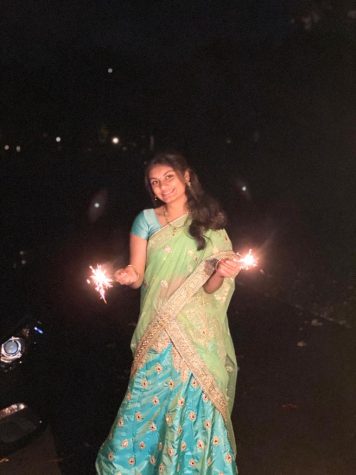 Sophomore Gayatri Dhavala holds firecrackers as she celebrates Diwali with her family.