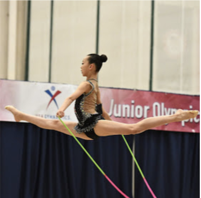 Rhythmic gymnast Kaylee Baek is performing her rope routine in the National Junior Olympics competition.