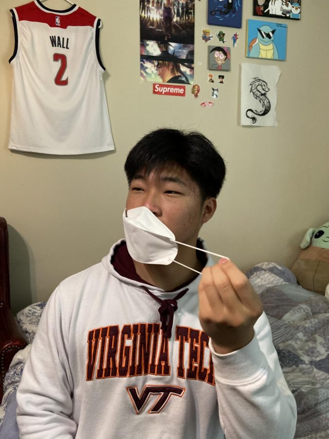 Freshman Eric Kim takes off his mask on May 18 to embrace the new CDC regulations.