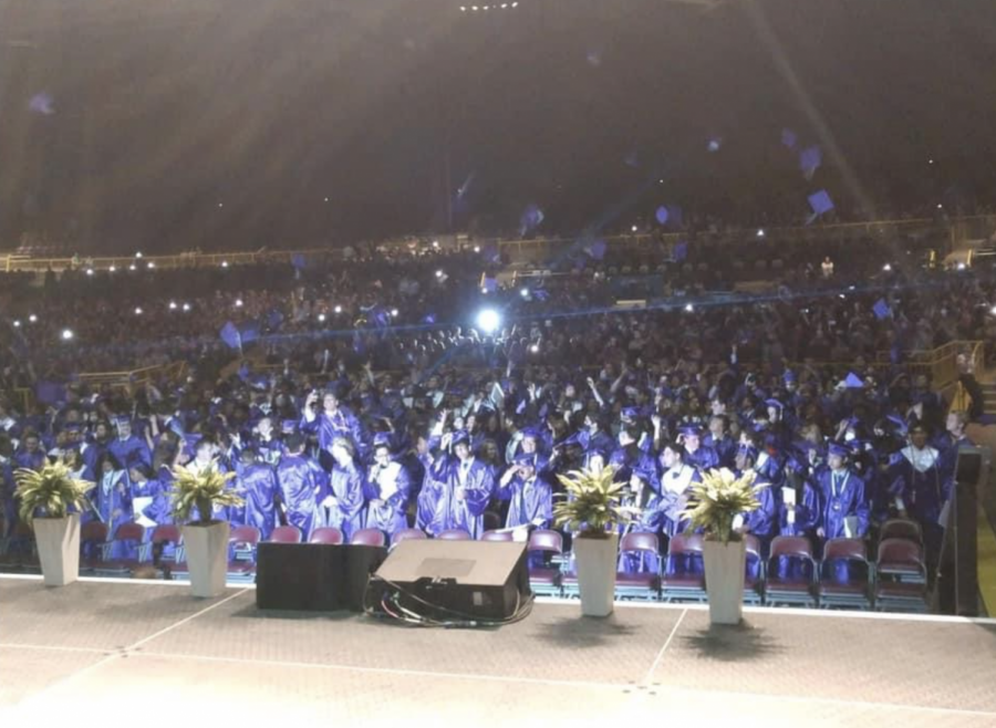 Students throw their caps into the air to celebrate graduation at Jiffy Lube Live on June 2.
