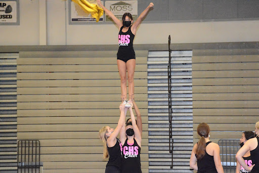 On Sept. 16, junior Amber Villanueva practices her routine with her stunt group of freshman Brianna Wade, junior Lauran Carr and junior Sammie Senio during cheer practice.