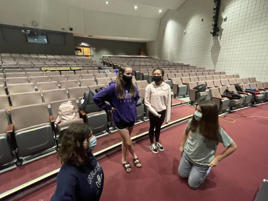 Senior Edie Obenberger, junior Lucy Sherrier, senior Kaela Francisco and junior Anna Dimauta discuss meeting Kacey Caliba while the rest of the ensemble prepares the stage for rehearsal on Sept. 21, in the auditorium.
