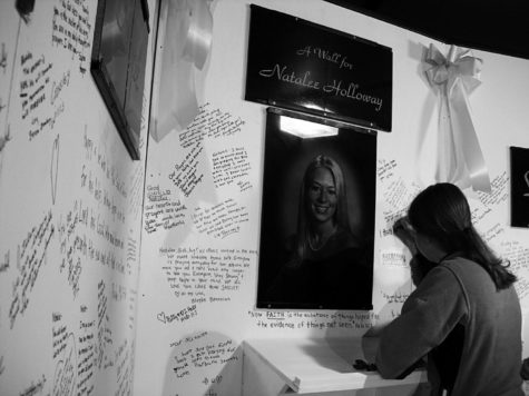 On June 10, 2005, a young lady signs a memorial wall for Natalee Holloway, less than two weeks after her disappearance. This case is another example of the White Woman Syndrome. 