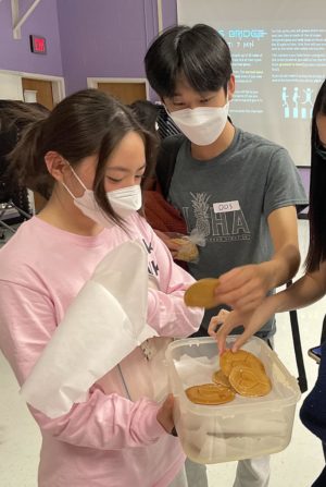 At the end of the “Squid Game” competition held by the Asian Student Association (ASA) on Oct. 12, senior and ASA research committee member Erica Lee rewards senior Adrian Kim, one of the winners, with a homemade dalgona in similar design to that in the show.