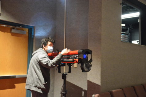 Pointing the blue spotlight, sophomore Sam Ryu practices lighting the school’s auditorium on Feb. 22. Spotlights highlight points of interest in the play. They are also used to set the mood of certain scenes and aid in changing from scene to scene more seamlessly. 