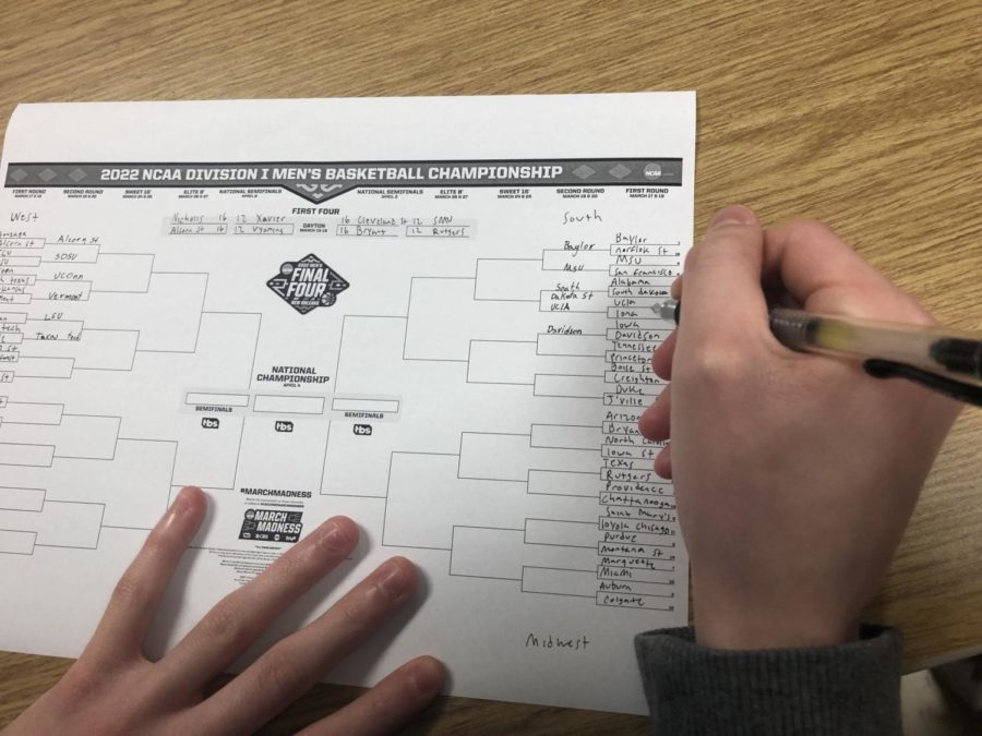 Before the tournament bracket is released,  A student fills out a practice bracket to prepare. 