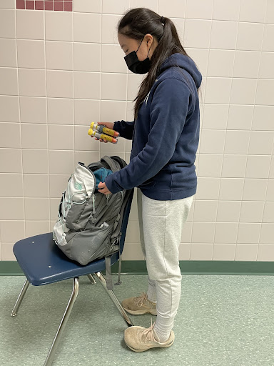 Opinions editor and junior Katelyn Chu packs her epinephrine injectors (Epipens) in her backpack, after lunch. Those with severe food allergies must carry Epipens with them at all times, as the adrenaline in the shot reduces symptoms of anaphylaxis, according to the Mayo Clinic. 
