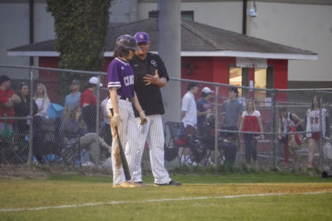 Catcher Jackson Ford strategizes with his coach about what to do in his next at-bat.