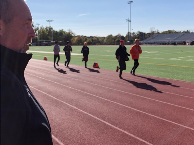 Gilchrist watches over his athletes while they run through their warm-up laps on Oct. 20.