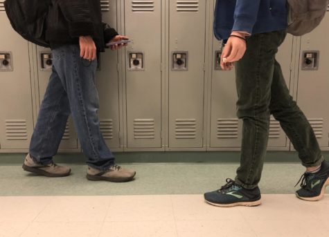 Two students pass by a set of hall lockers. In a poll taken with 103 student responses, 92 respondents would like to see these spaces converted into sitting areas or other new additions.