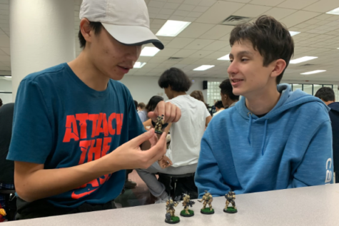 Freshmen Sammy Lim and Aidan Daly discuss painted miniature figures of characters from the tabletop game “Warhammer 40,000” during lunch on Wednesday, Jan. 4. Lim, who painted the miniature figures by hand, plans to present them at a D&D Club meeting.