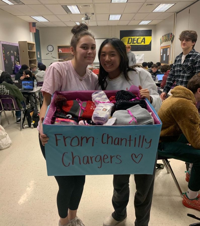 Seniors and co-presidents of Chargers Against Cancer Lily Karabulut and Madeleine Ngo gather the hats and socks from the clothing drive to donate to the Inova hospital