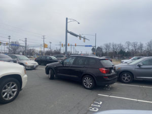 A student pulls out of their spot into a line of cars in West Lot after school. “Specifically in that parking lot, it gets super congested, and there’s too many cars trying to get out at once,” junior Grace Drost said. “It makes people panic sometimes.” 