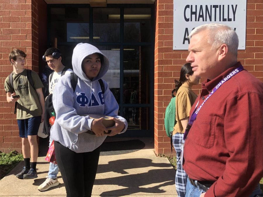 Academy counselor Sean McCoart converses with South Lakes High School junior Amariee Mayo while he supervises shuttle pickup on Feb. 15.