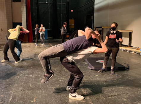 Senior Jack Wolff and junior Zach Smith practice lifts during a rehearsal on March 15 as sophomore Rachel Shear oversees production. 