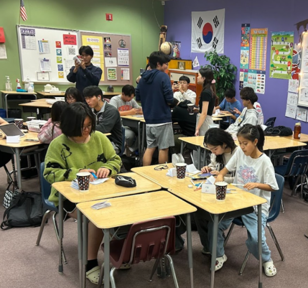 Korean Honor Society members work on their Korean alphabet book for Colin Powell Elementary School and eat rice cake snacks on Oct. 25.