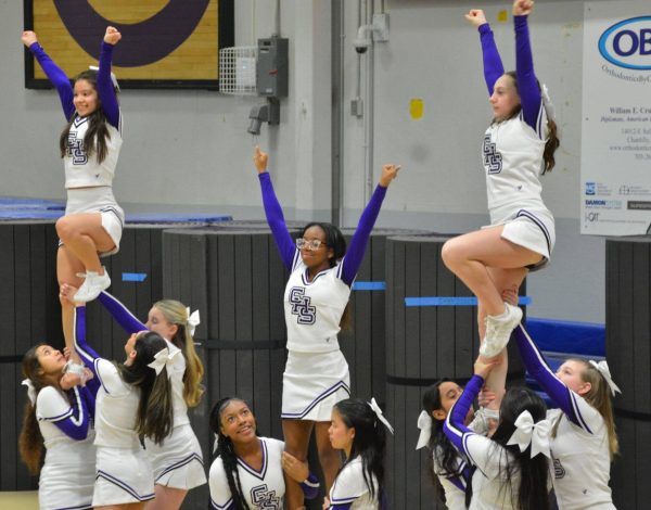 Sophomore Melanie Nolasco, freshman Lucy Milans and sophomore Tissara Vassell are lifted up in the air for a formation. 
