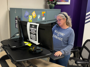 Administrative Assistant Jennifer Kudlacik stands at her desk while working.