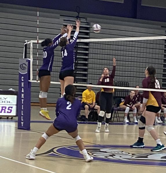 Sophomore Skyler Riley and junior Julia Horan try to block a ball while junior Apria Smith prepares for the ball to cross the net in a 3-1 victory against Oakton High School on Sept. 27.