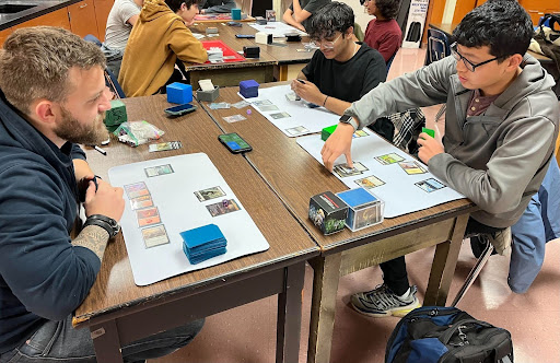 AP Environmental Science teacher Joshua Cooper and juniors Aryan Banda and Bryce Yang compete in a match of Magic: The Gathering after school on Nov. 25. 