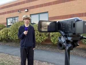 The Knightly News reporter sophomore John Kosinski records the intro to his segment on March 20. Before his segment airs, student producers and the publication’s faculty adviser will view and approve it. 