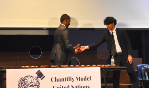 Senior Secretary-General Ram Dosibhatla shakes hands with sophomore middle school crisis chair Athri Cheboli and gives him his committee’s gavel. “MUN teaches primarily three main skills,” Dosibhatla said. “It teaches you how to gather information across multiple sources, and how to speak to other people to develop collaborative results.”

