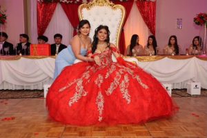 Freshman Leydi Sandoval Ramirez displays a red ball gown with gold embroidery, styled in loose curls, a tiara and soft glam makeup on Mar 22 photo courtesy of AleLuna Studio LLC.
