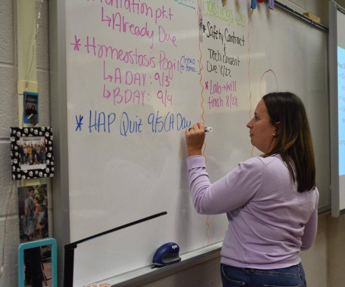 Science teacher Ashley Hastings writes the date for an upcoming anatomy quiz on the board on Aug. 28.