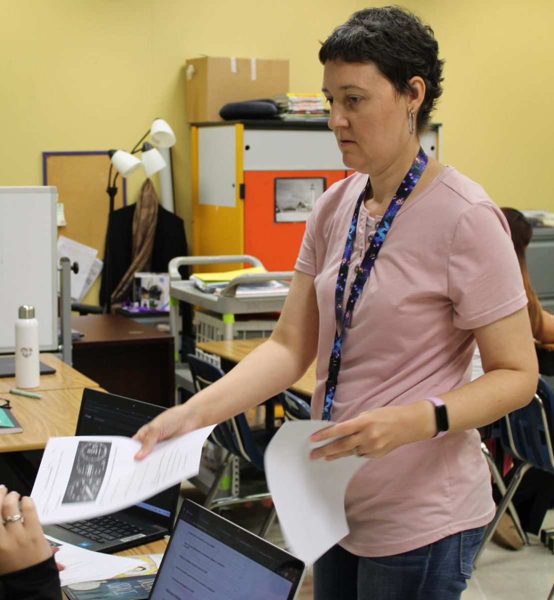 English Speakers of Other Languages (ESOL) teacher Alesha Nielsen hands worksheets for her students to practice applying claim, evidence and reasoning in their sentences on Aug. 28.