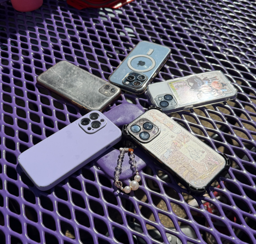 The cellphones of multiple students lay face down on a table during lunch on Oct. 9. The new policy only allows students to use their phones during their lunch break.