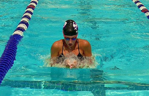 Senior Ellie Bennett takes a breath while swimming during a meet at Cub Run Recreation Center on July 3 against where she placed second in the 50 meter breastroke