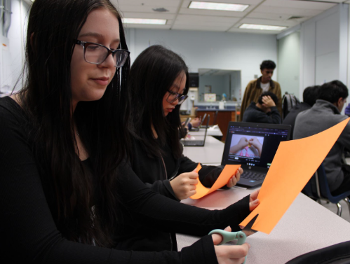 Juniors Macie Brooks and Jeanna De Jesus craft paper Parols with help from a video guide on Nov. 21. 