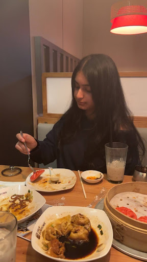 Senior Hamsini Katasani tries a bite of Ugly Dumpling’s popular chicken soup dumplings. 
