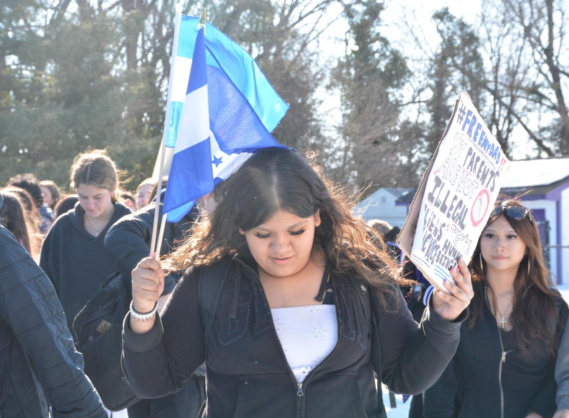 On Feb. 13, junior Daniela Ramos Flores waves a Honduran and Guatemalan flag while raising a poster that reads, “#Free my dad!! My parents are not illegal aliens, they’re human beings.” 
