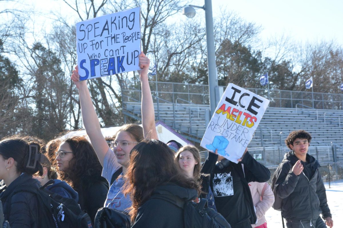 During the ICE walkout on Feb. 13, students raise posters that read, “Speaking up for the people who can’t speak up,” and “ICE melts under resistance.”
