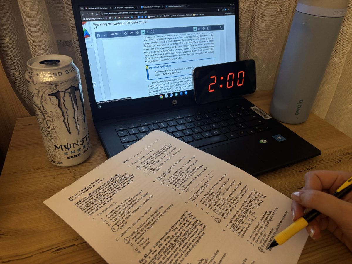 An energy drink sits beside unfinished work as a student studies past midnight to meet academic demands.  