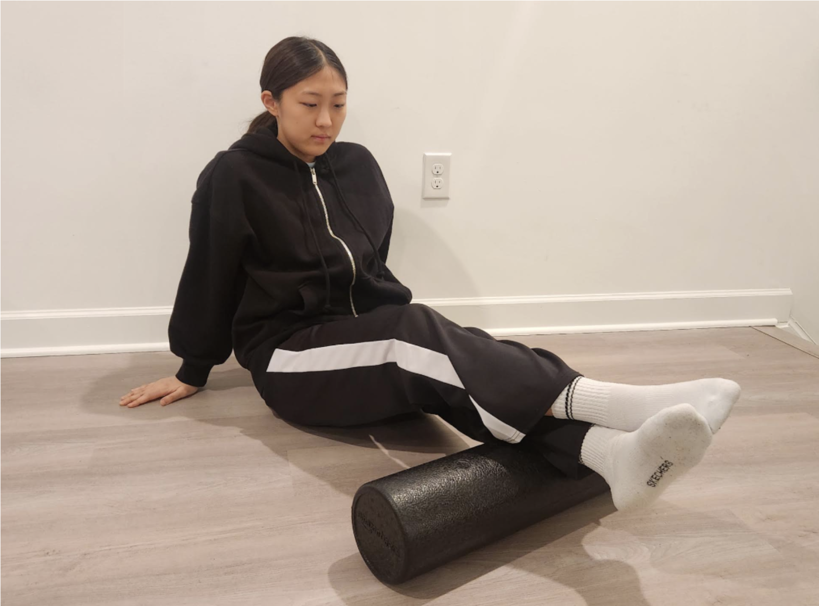 Junior Kaylyn Yu rolls her calf before practice to relax her muscles on March 3. Track athletes, in preparation for tryouts, warmup by stretching. Photo courtesy of So Yean Yu.
