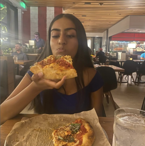 Junior Medha Kumawat takes a bite of a slice of Margherita pizza at North Italia on Oct. 11.

