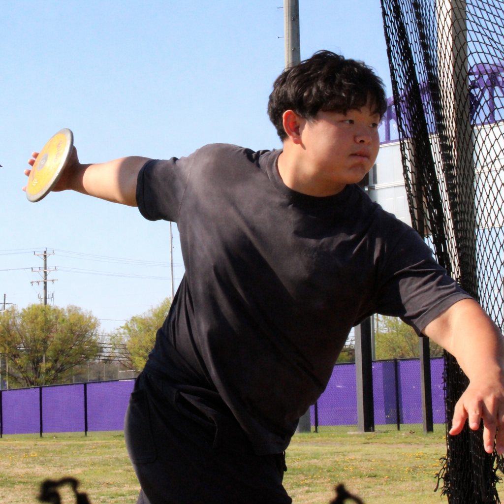 Junior Christopher Hwang gathers momentum to throw the discus high and far into the air.