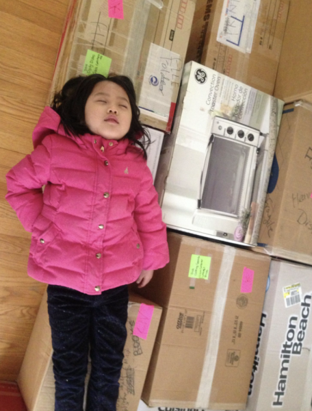 On Dec. 17, 2014, 6-year-old Lizzie Sun lies on a couple of boxes after moving into her new house. Photo used with permission by Helen Sun.
