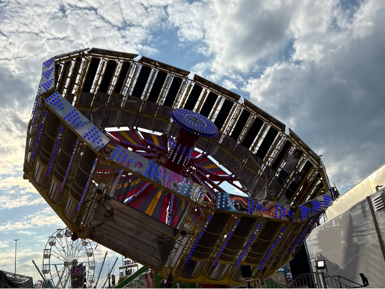 Riders stand upright as the “Zero Gravity” attraction spins, half lifted in the air.