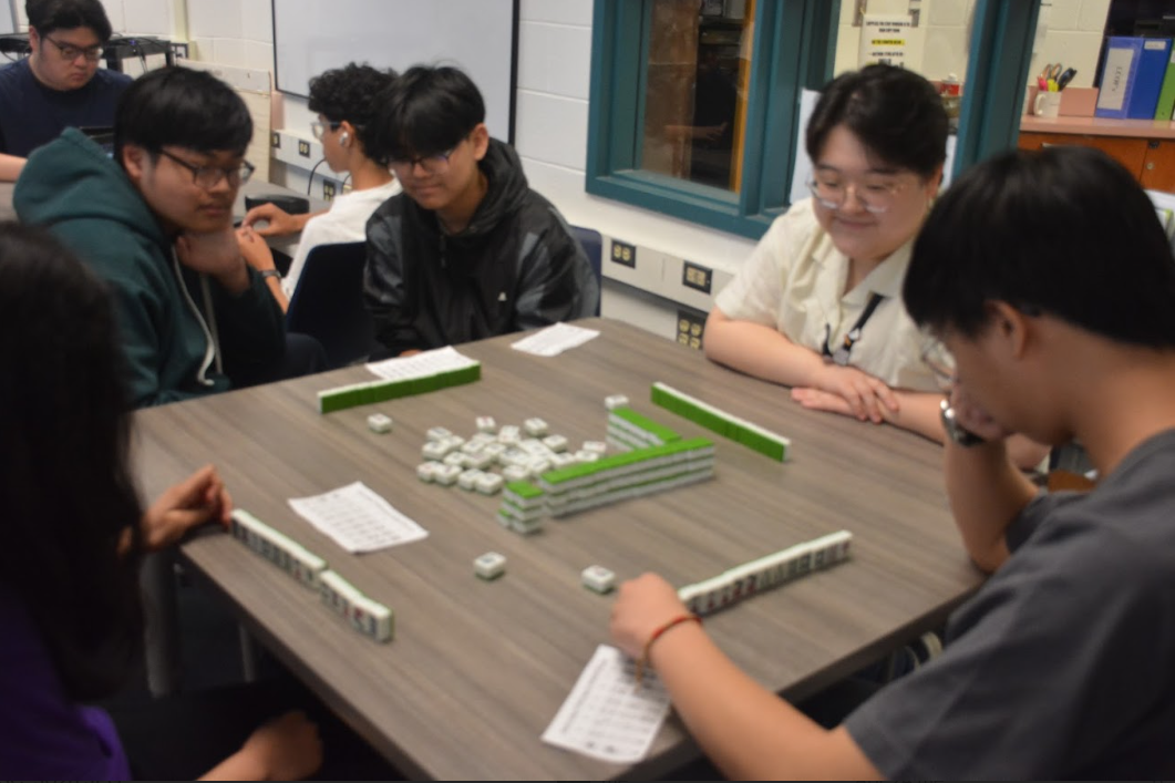 English substitute teacher Saniya Lee plays mahjong with students in the library.